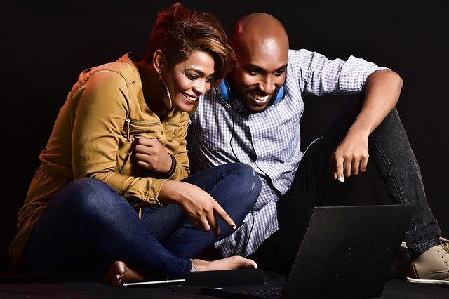 adult couple watching an entertaining program on a laptop
